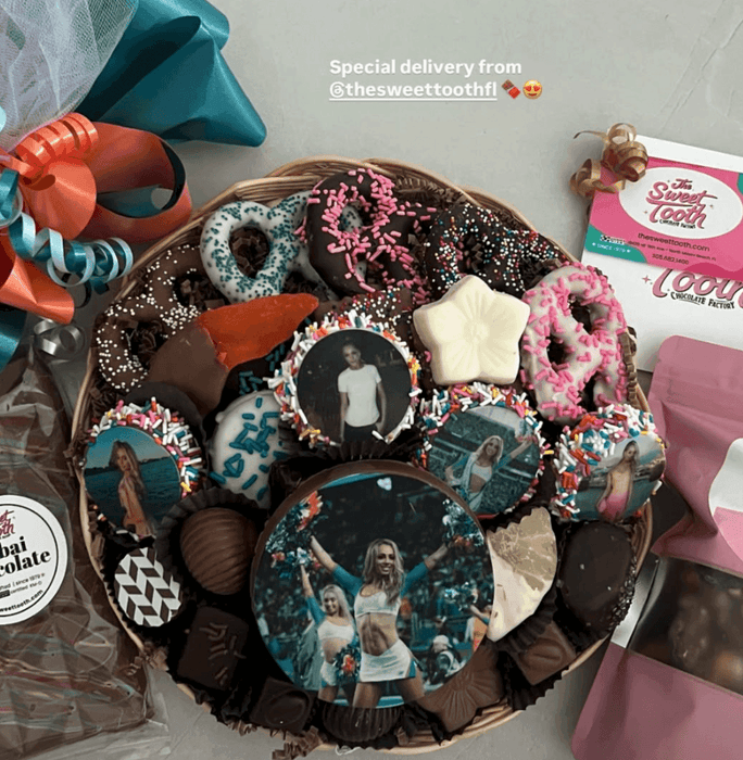 Assorted gift basket with personalized chocolate Oreos featuring cheerleader photos. Unique edible gift for sports fans or celebrations.