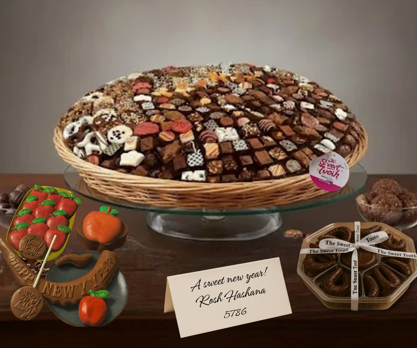Assorted chocolate tray with a card wishing a 'sweet new year' on a wooden table.