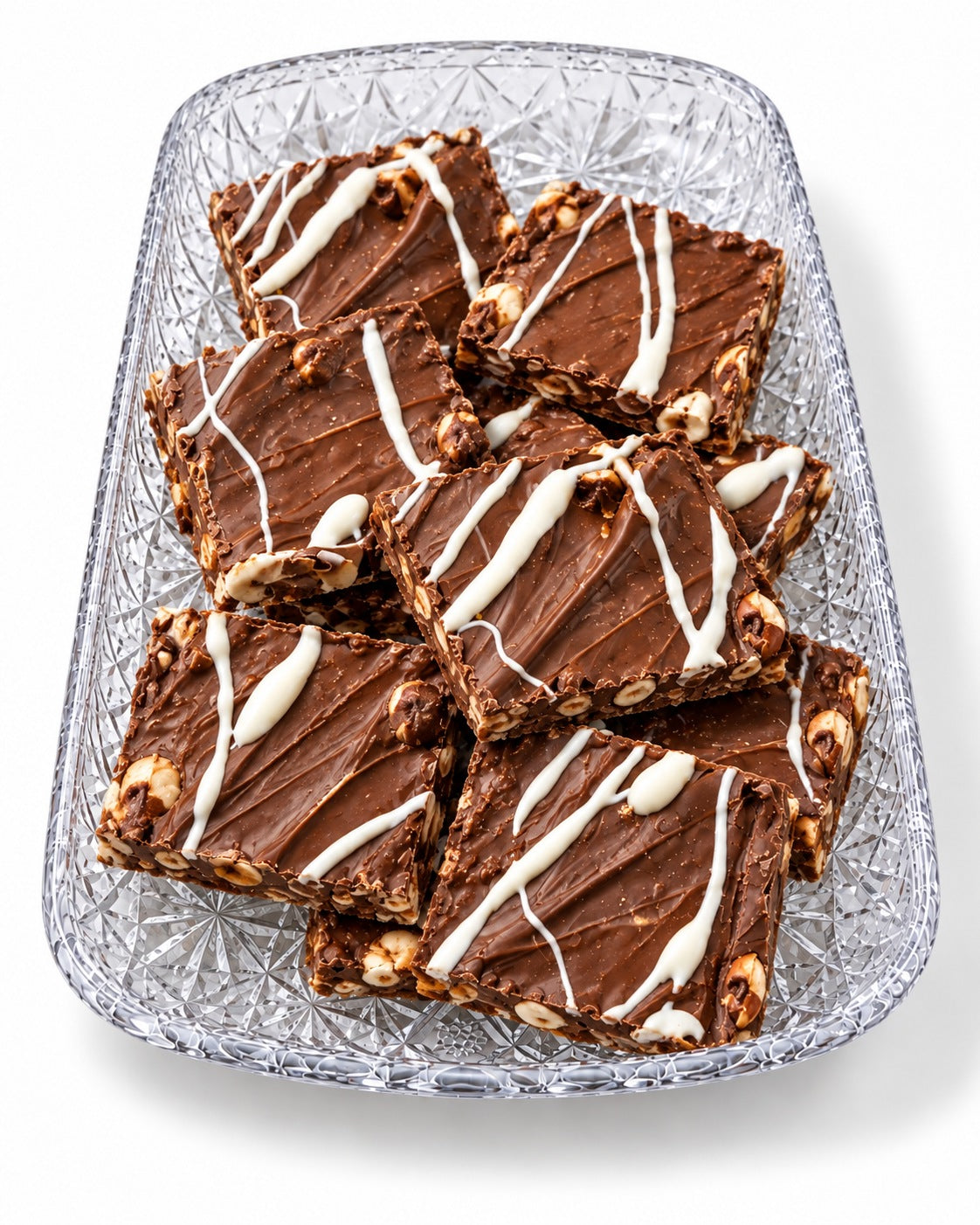 Sea Salt Hazelnut chocolate bark with a white chocolate drizzle on a glass tray