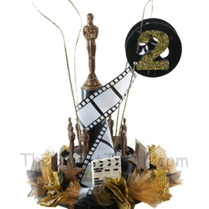 Hollywood Centerpiece featuring gold Oscar-style statues, film reels, and glittery number 2 for custom glamour at themed event decor.