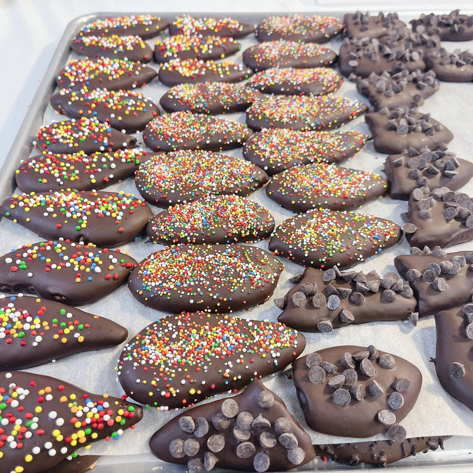 PENULTIMATE - Passover chocolate-dipped fruit slices with rainbow sprinkles and chocolate chips, a colorful kosher holiday treat.