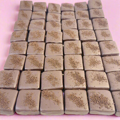 Square chocolate pieces topped with cocoa dusting from SUPREME - Passover collection, ideal for elegant food gift baskets.
