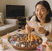 Woman holding a card with a sweet tooth logo next to a basket of chocolates.