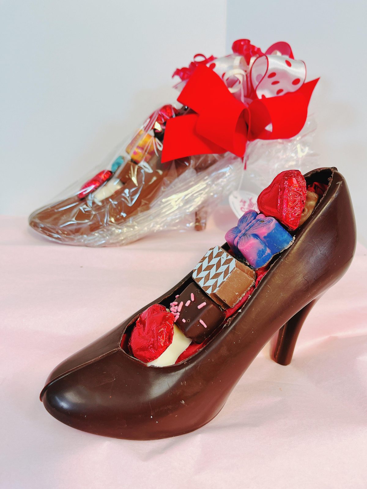 Gourmet chocolate high heel filled with truffles and wrapped for gifting, combining fashion and sweets in a creative treat.