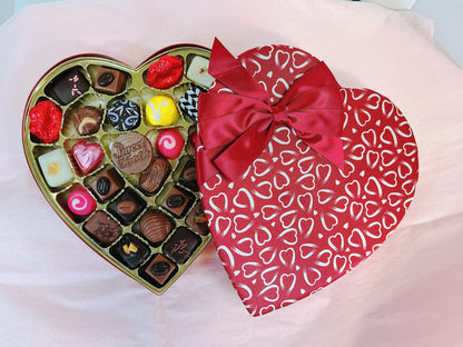 Heart-shaped box of assorted Valentine's chocolates with red bow, part of The Ultimate Valentine’s Day Bundle gift set.