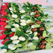 Tray of chocolate roses in red, white, and milk chocolate with green leaves, great for party treats or festive gift arrangements.