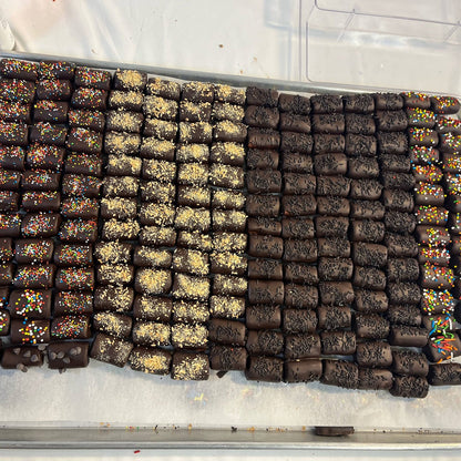 Assorted chocolate-covered logs with toppings from SUPREME - Passover, perfect for gourmet food gift basket collections.
