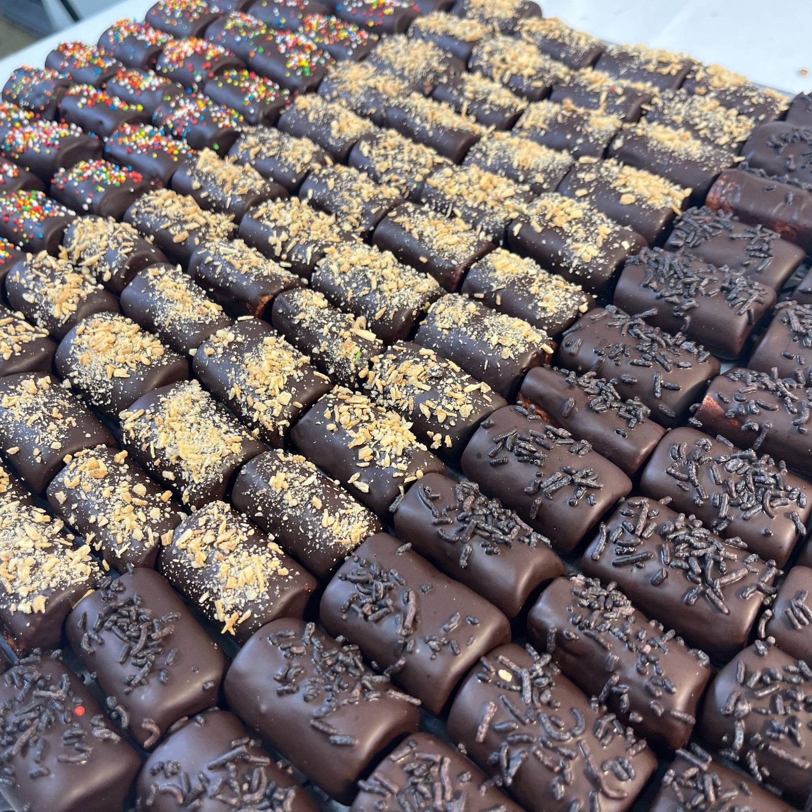 PENULTIMATE - Passover chocolate-covered logs topped with sprinkles and crushed nuts, ideal for festive kosher gift baskets.