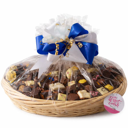 Basket of assorted chocolates with a decorative bow on a white background