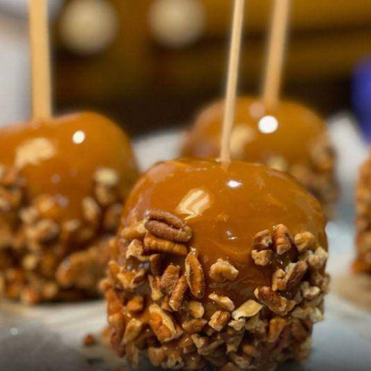 Caramel apples with pecans on sticks on a blurred background sweet tooth kosher 