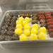Assorted chocolates including yellow, red, and brown on a tray.