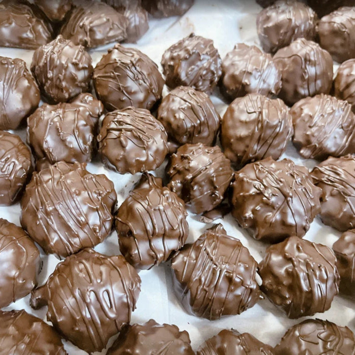 Close-up of chocolate truffles on a white surface