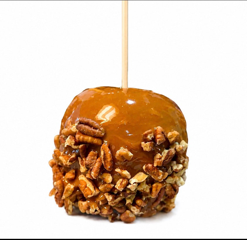 Rosh Hashanah caramel apple rolled in chopped pecans on a stick, glossy house-made caramel over a fresh apple, kosher, from The Sweet Tooth in Miami