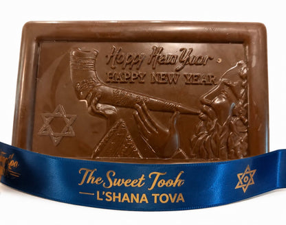 Rosh Hashanah chocolate bar with molded rabbi blowing a shofar, Star of David, and 'Happy New Year' greeting, wrapped with a blue L'Shana Tova ribbon from The Sweet Tooth