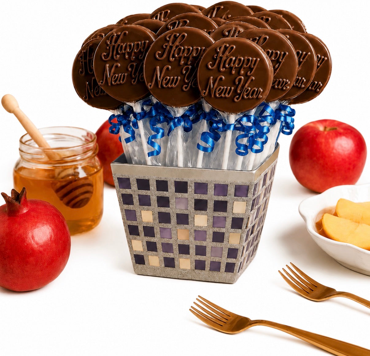 Rosh Hashanah chocolate lollipops gift set — 18 'Happy New Year' chocolate pops with blue ribbon in a silver mosaic box, styled with apples, honey, and pomegranates