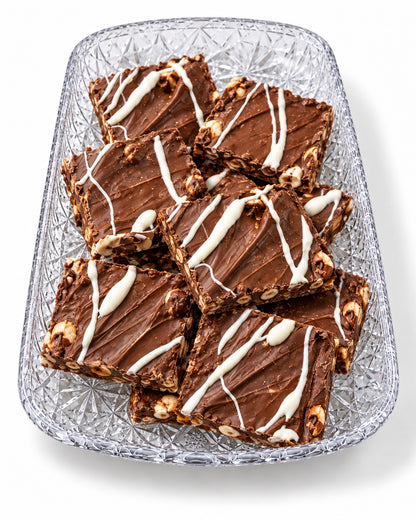 Sea Salt Hazelnut chocolate bark with a white chocolate drizzle on a glass tray