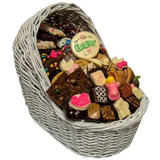 Baby Bassinet Gift Basket filled with 46 gourmet treats in a white wicker bassinet, perfect for welcoming a baby girl with sweet delights.
