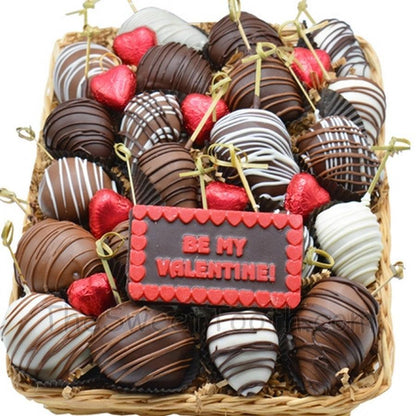 Chocolated dipped strawberries for Valentine's Day arranged in a festive basket with red heart candies and a 'Be My Valentine' chocolate plaque.